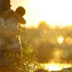 selective focus photography of woman carrying baby